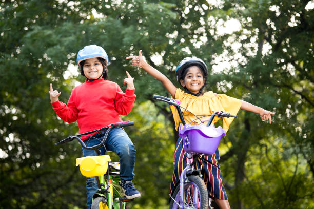 istock Boy and girl having fun on bicycle at park 1194826116