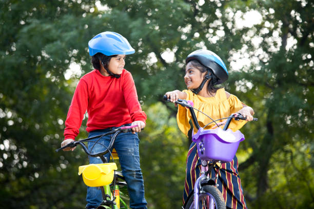 istock Boy and girl having fun on bicycle at park 1194826250