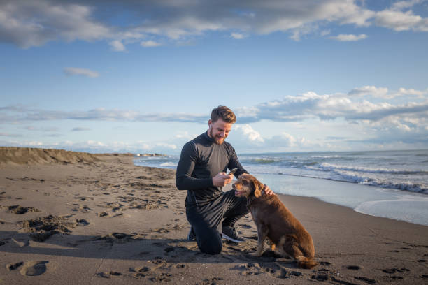 istock Male runner is having some rest after morning jogging with his dog. He is using phone for a call and taking picture of his furry friends. 1194829105