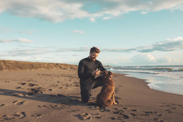 istock Male runner is having some rest after morning jogging with his dog. He is using phone for a call and taking picture of his furry friends. 1194830093