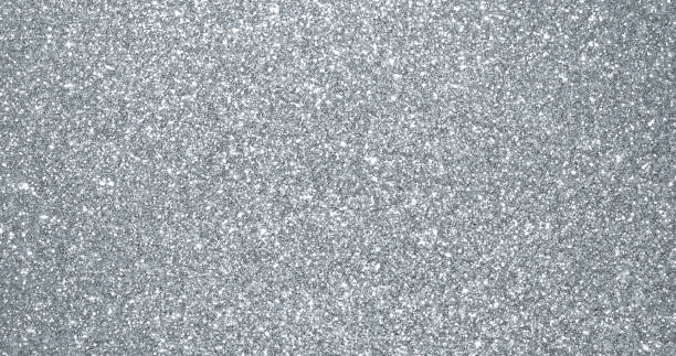 シルバーグリッターの背景、輝く輝く輝く粒子のテクスチャ。銀色の光の火花と輝くホイルスパンコールの背景に輝く火花がまぶしい - スパンコール ストックフォトと画像