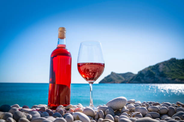 istock Red wine and wine glass on the beach 1194831820