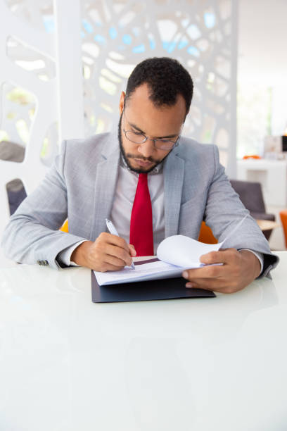istock Serious businessman writing on papers 1194832695