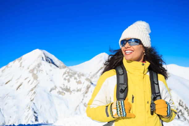 Female backpacker hiking in snow mountain
