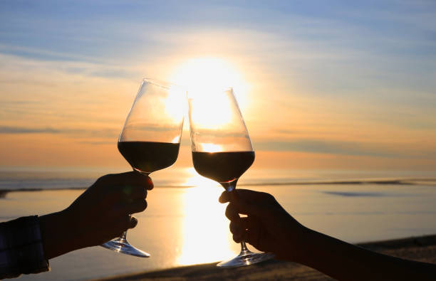 stato d'animo di tempo felice con scena tramonto e coppia romantica o amicizia che momento felice rilassante ,rosso,wineglass,celebrazione sulla spiaggia - wine red red wine cocktail foto e immagini stock