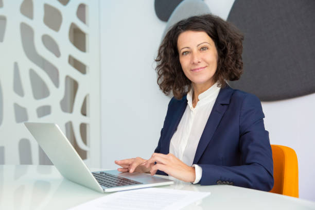 istock Cheerful businesswoman using laptop 1194833576