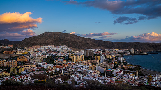 Spain, Tenerife, Tourist resort city in south, houses of los christianos with colorful sunset sky clouds in magical twilight atmosphere from above