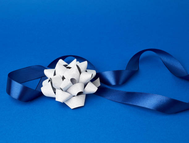 istock blue silk thin ribbon twisted on a blue background 1194834968