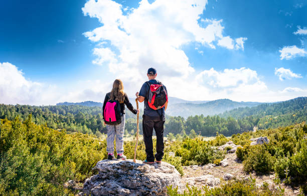 Trekking father and daughter on autumn mountain tip