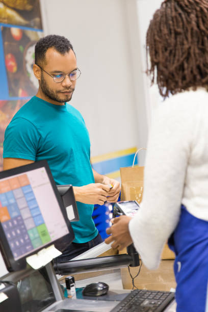 istock Back view of cashier using card reader at checkout 1194841976