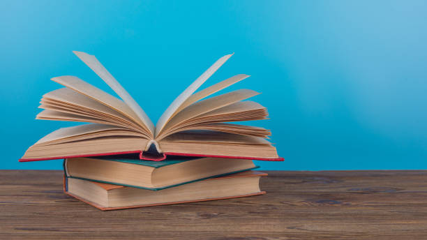 istock A beautifully open book, page, lies on a table with a blue background. 1194843134