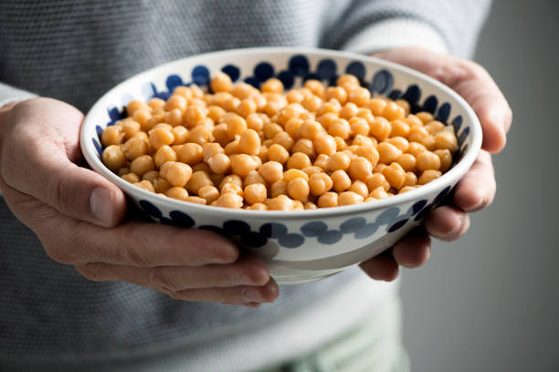 ひよこ豆のボウルを持つ男 - cooked chick peas ストックフォトと画像