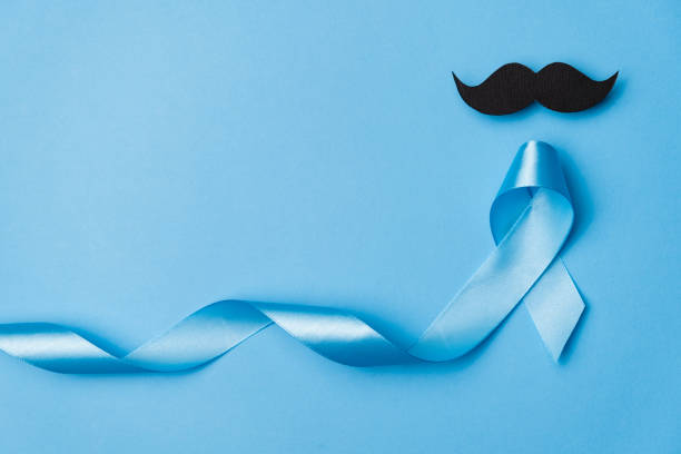 istock Top view on Light blue ribbon with mustache on blue background . Prostate Cancer Awareness, Movember Men's health awareness, November Blue, International Men's Day 1194848342