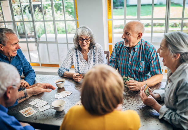 istock Senior friends having fun playing cards 1194848402