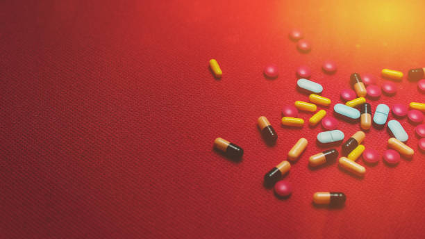 istock Assorted pharmaceutical medicine pills, tablets and capsules on Red background with copy space 1194848446