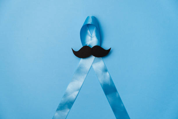 istock Top view on Light blue ribbon with mustache on blue background. Prostate Cancer Awareness, Movember Men's health awareness, International Men's Day 1194849631