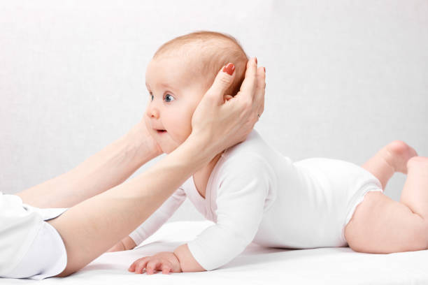 little baby receiving osteopathic treatment of head and neck - human vertebra fotos imagens e fotografias de stock