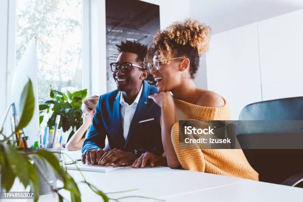 Two Business Professionals Happily Working In Office Stock Photo - Download Image Now