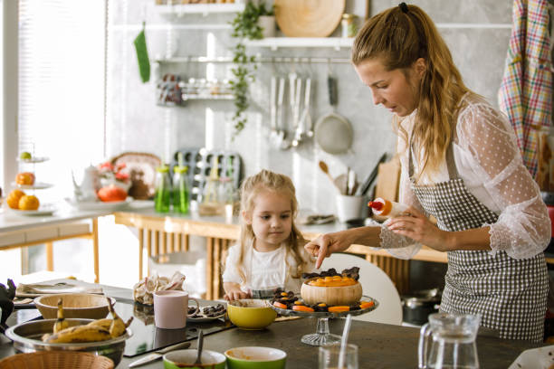 istock Mother's little assistant decorating desserts with her 1194855647