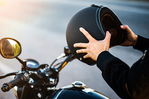 Pareja de motocicletas sosteniendo cascos en las manos. photo
