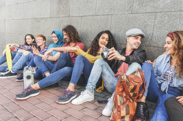 istock Young millennial friends having fun chatting, taking photos with vintage camera and using smartphones - Youth, generation z, tech trends and multiracial concept - Main focus on right guy face 1194859007