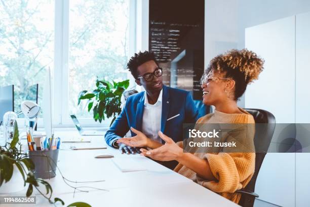 Business Executives Discussing In Office Stock Photo - Download Image Now - 30-34 Years, Adult, Adults Only