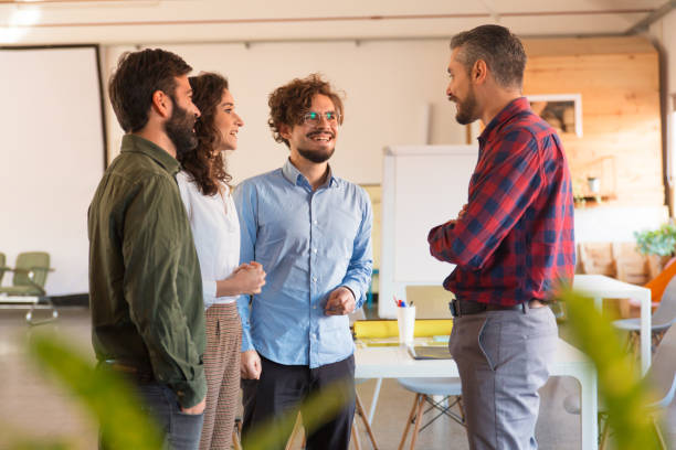 istock Startup team reporting to leader, smiling, laughing 1194863886