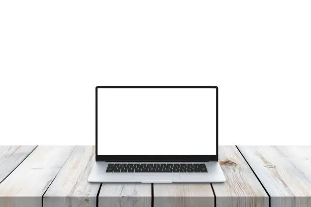 Laptop on wooden desk with isolated screen for mockup and background. Close-up