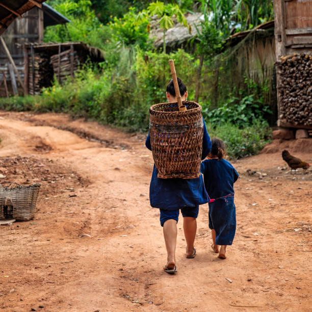 лаосская мама гуляет с дочерью в деревне в северном лаосе - laos hut southeast asia shack стоковые фото и изображения