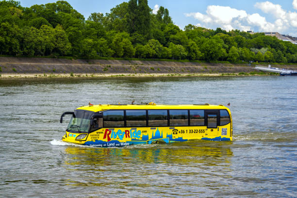 Sightseeing cruise amphibious yellow bus in Budapest, Hungary Budapest/Hungary- May 8, 2018: sightseeing cruise amphibious yellow bus – River Ride – floating in Danube River water along the Margit Island with green trees on the coast. budapest danube river cruise hungary stock pictures, royalty-free photos & images