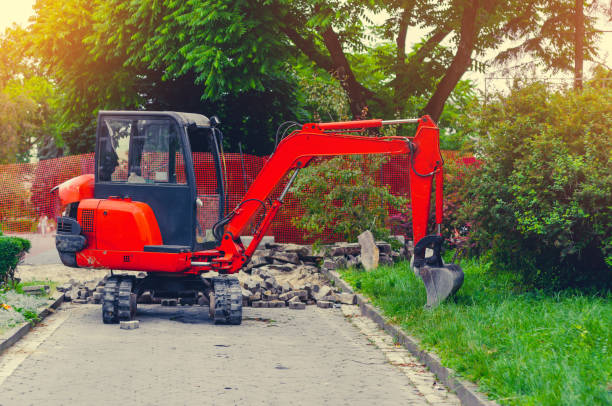 mała koparka na chodniku w pobliżu trawnika. naprawa w mieście, miejskim - earth mover working field dirt zdjęcia i obrazy z banku zdjęć