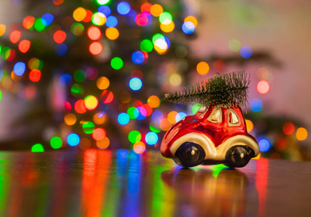 Miniature Red Car with Christmas Tree Lights in Background