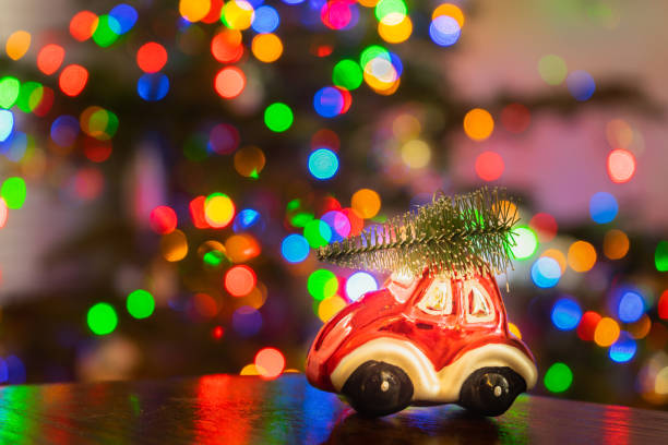 istock Miniature Red Car with Christmas Tree Lights in Background 1194871467