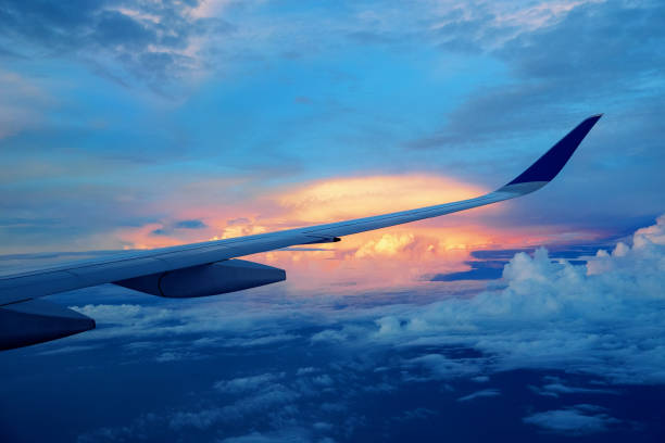 istock Close-up of airplane wing flying above clouds 1194872037
