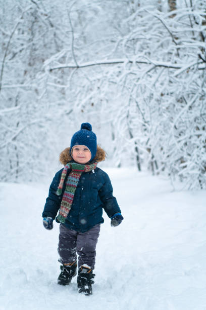istock Happy child walking through winter forest 1194874453