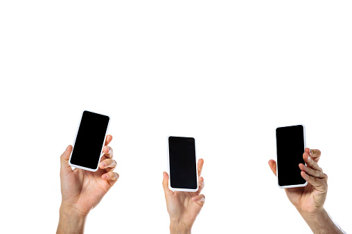cropped view of young friends holding smartphones with blank screens isolated on white