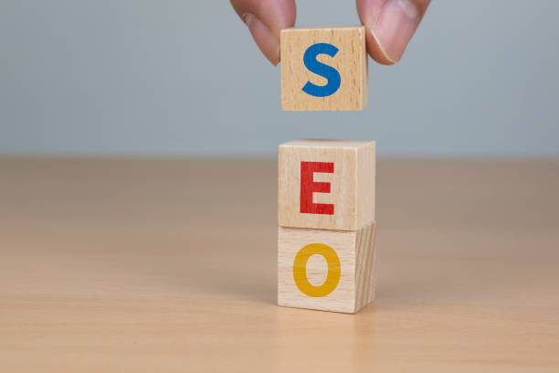 istock Search engine optimization concept. Hand putting wood block cube shape with word SEO 1194879780