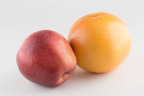 manzanas y naranja aisladas sobre un fondo blanco - comparison apple orange isolated fotografías e imágenes de stock
