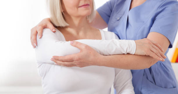 istock Physiotherapist working with middle aged patient in clinic 1194883400