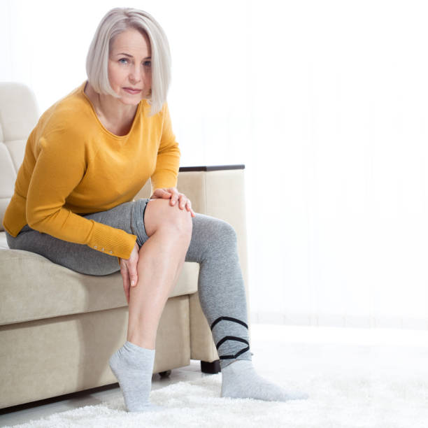 Middle-aged woman suffering from pain in leg at home, closeup. Physical injury concept. Middle-aged woman suffering from pain in leg at home, closeup. Physical injury concept. Ankle pain, painful point. painfully stock pictures, royalty-free photos & images