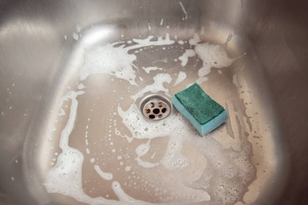 istock Kitchen cleaning and cleaning. Blue kitchen sponge with metal kitchen sink 1194883594