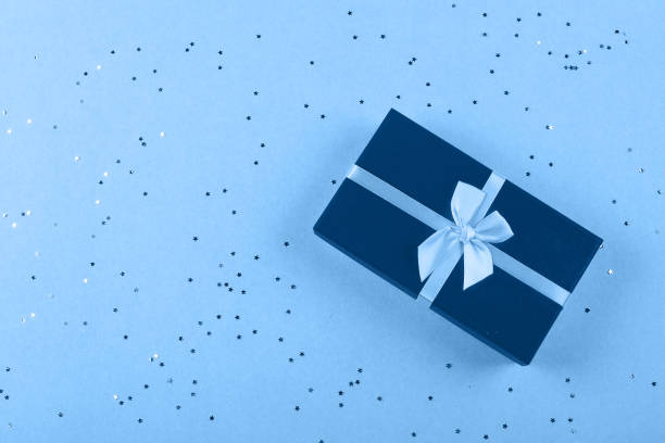 istock One blue gift box with sparkles on a light blue background. Christmas, birthday, holiday concept. Top view, flat lay, copy space 1194884705