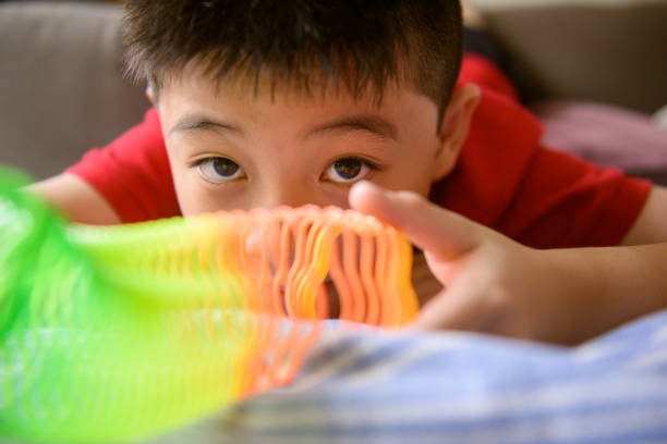Asiab boy playing flower shape slinky rainbow spring