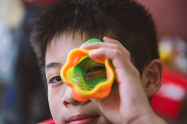 Asiab boy playing flower shape slinky rainbow spring