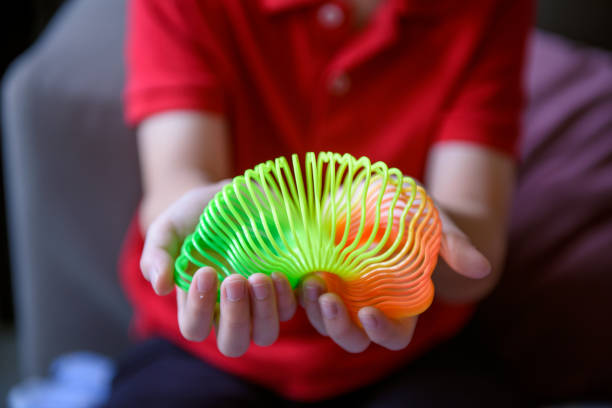 Asiab boy playing flower shape slinky rainbow spring