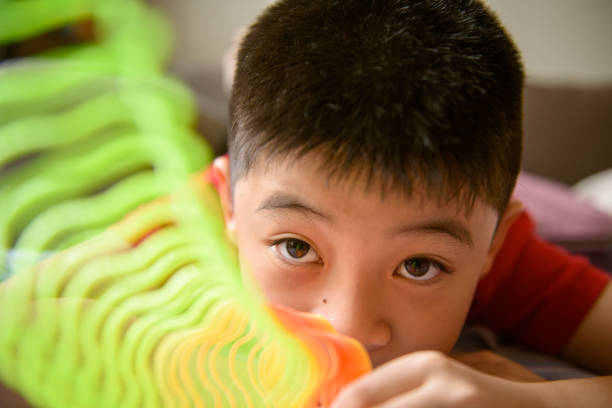 istock Asiab boy playing flower shape slinky rainbow spring 1194886856