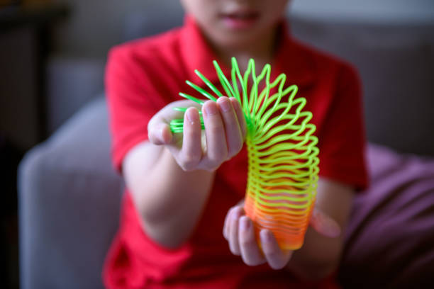 Asiab boy playing flower shape slinky rainbow spring