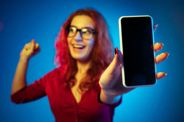 istock Caucasian woman's portrait isolated on blue studio background in neon light 1194886960