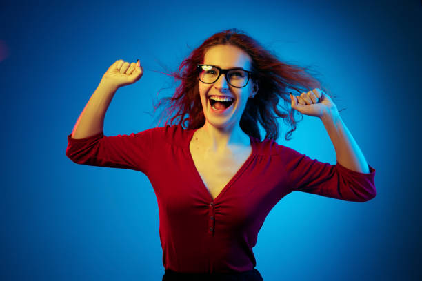 istock Caucasian woman's portrait isolated on blue studio background in neon light 1194887000
