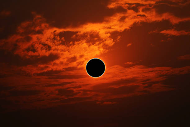 istock phenomenon of partial sun eclipse over silhouette orange cloud and sunset sky 1194887014
